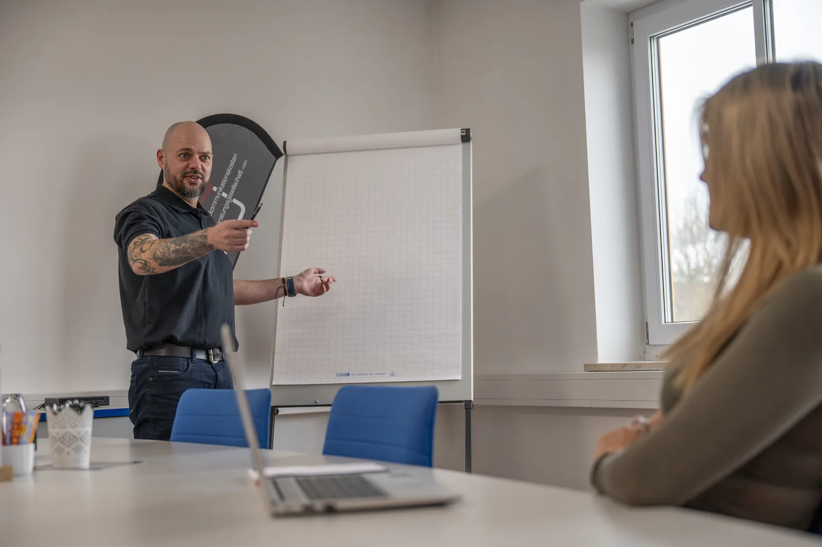 UTB-Mitarbeiter erläutert einer Kundin am Flipchart die Auswertung